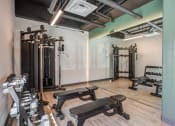 Thumbnail 16 of 33 - a fitness room with weights machines and a mirrored wall