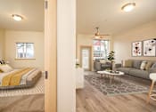 Thumbnail 3 of 29 - A bedroom with a bed, a couch, a coffee table, and a ceiling fan. at Fairview Village Apartments, Fairview, OR