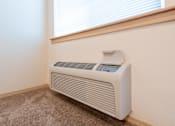Thumbnail 7 of 29 - A white electric heater is on the floor next to a window. at Fairview Village Apartments, Fairview, 97024