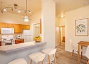 Thumbnail 1 of 29 - A kitchen with a counter and chairs. at Fairview Village Apartments, Fairview, OR, 97024