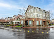 Thumbnail 12 of 34 - A row of townhouses with a wet street in front. at Fairview Village Homes, Fairview, OR, 97024
