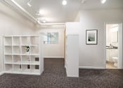 Thumbnail 18 of 36 - A room with a white shelf, a plant, and a picture on the wall.at Palladian Apartments, Portland, OR ? 