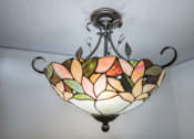 Thumbnail 28 of 36 - A stained glass chandelier with a floral design hangs from the ceiling.at Palladian Apartments, Portland, OR 97201 ? 