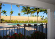 Thumbnail 4 of 28 - Oaks at Pompano resort style swimming pool lined with palm trees and lounge chairs1 at Oaks at Pompano, Pompano Beach, Florida