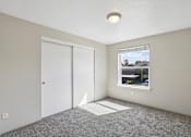 Thumbnail 9 of 39 - A room with a window, carpeted floor, and a ceiling light.