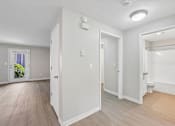 Thumbnail 10 of 39 - A white room with a door on the left and a window on the right.