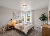 Thumbnail 6 of 39 - A bedroom with a large bed and a window overlooking a green landscape.