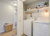 Thumbnail 5 of 39 - A small laundry room with a washer and dryer.