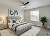 Thumbnail 23 of 39 - A bedroom with a large bed, a ceiling fan, and a potted plant.