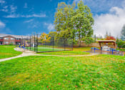 Thumbnail 26 of 39 - A park with a playground and a fence.