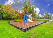 Thumbnail 30 of 39 - A playground with a red and yellow slide and a blue and yellow climbing frame.