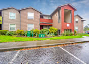 Thumbnail 29 of 39 - A row of townhouses with a parking lot in front.