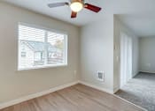 Thumbnail 34 of 39 - A room with a ceiling fan and a window overlooking a house.