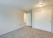 Thumbnail 31 of 39 - A room with a carpeted floor and two white doors.