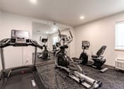 Thumbnail 11 of 20 - A well-equipped gym with treadmills, elliptical machines, and other exercise equipment.