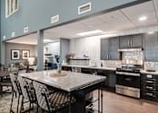 Thumbnail 10 of 20 - A modern kitchen with a large island and stainless steel appliances.