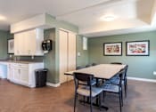 Thumbnail 18 of 20 - A kitchen with a table and chairs in the middle of the room.