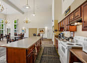 Thumbnail 24 of 26 - A kitchen with a white stove top oven and a white microwave at Vintage at Burien, Burien, WA
