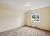 Thumbnail 11 of 26 - Empty room with a window showing a parking lot outside at Vintage at Burien, Washington.