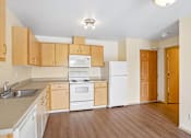 Thumbnail 5 of 26 - A kitchen with wooden cabinets and white appliances at Vintage at Burien, Burien.