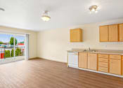 Thumbnail 7 of 26 - A kitchen with wooden cabinets and a white dishwasher at Vintage at Burien, Washington