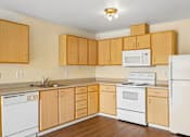 Thumbnail 6 of 26 - A kitchen with wooden cabinets and white appliances at Vintage at Burien, Washington,98168