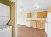 Thumbnail 8 of 26 - A kitchen with white appliances and wooden cabinets at Vintage at Burien,Burien,WA,98168
