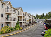 Thumbnail 2 of 26 - A row of apartment buildings with a parking lot in front at Vintage at Burien, Burien ,Washington