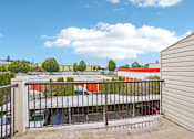 Thumbnail 15 of 26 - A view from a balcony looking at a building with a red roof at Vintage at Burien, Burien, WA