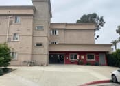 Thumbnail 3 of 5 - the front of a building with a driveway and a bike parked in front