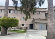 Thumbnail 1 of 5 - an apartment building with a sidewalk and palm trees