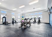 Thumbnail 7 of 18 - A gym with a variety of exercise equipment including treadmills, stationary bikes, and elliptical machines at View by Vintage Apartments, Washington, 98391