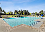 Thumbnail 9 of 18 - A large outdoor swimming pool with a diving board at View by Vintage Apartments, Bonney Lake, Washington