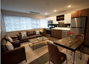 Thumbnail 31 of 33 - A modern kitchen and living room with brown leather furniture.