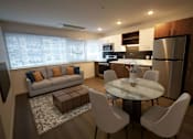 Thumbnail 30 of 33 - A modern kitchen with a dining table and chairs.