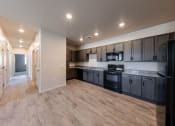 Thumbnail 1 of 14 - an empty kitchen with black appliances and wooden cabinets at Springview by Vintage, Nevada, 89512