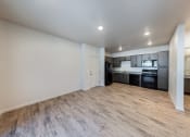Thumbnail 7 of 14 - an empty living room with a kitchen in the corner at Springview by Vintage, Reno, NV