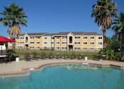 Thumbnail 3 of 21 - Swimming Pool with lounge chairs at Carolina Club Apartments, Daytona Beach, 32114