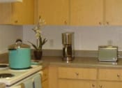 Thumbnail 10 of 13 - Apartment home kitchen space with white appliances and blonde colored cabinetry at Mariners Cove, Tampa, FL