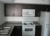 Thumbnail 9 of 14 - Mirabella Apartments kitchen area with white appliances and bar top for seating at Mirabella Apartments, Princeton, Florida