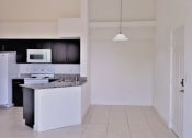 Thumbnail 11 of 14 - Mirabella Apartments kitchen area with white appliances and bar top for seating plus dining space at Mirabella Apartments, Princeton, FL