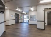 Thumbnail 2 of 27 - a lobby with a wood floor and white walls and doors