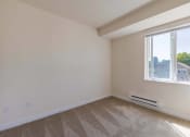 Thumbnail 13 of 27 - an empty bedroom with a large window and carpeting