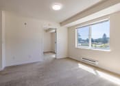 Thumbnail 15 of 27 - an empty living room with a large window and carpet