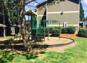 Thumbnail 19 of 52 - a swing set in front of apartment building with a tree at Fort Vancouver Terrace, Vancouver, 98661