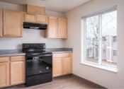 Thumbnail 32 of 52 - a kitchen with a black stove and a window at Fort Vancouver Terrace, Washington
