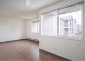 Thumbnail 38 of 52 - an empty living room with a large window and wood floors at Fort Vancouver Terrace, Washington