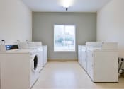 Thumbnail 8 of 50 - an empty laundry room with dryers and washing machines at Quail Run Apartments, Vancouver