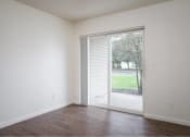 Thumbnail 11 of 50 - an empty living room with a sliding glass door to a yard at Quail Run Apartments, Vancouver, Washington