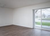 Thumbnail 14 of 50 - an empty living room with a large window and wooden floors at Quail Run Apartments, Washington 98684